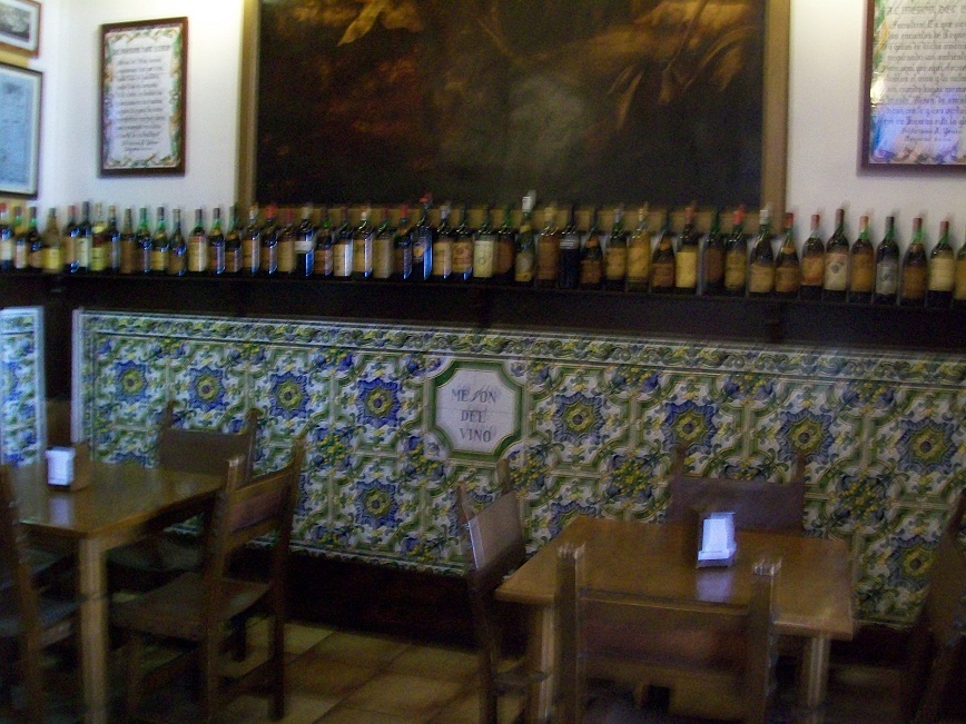 a shelf running along the wall holds hundreds of wine bottles